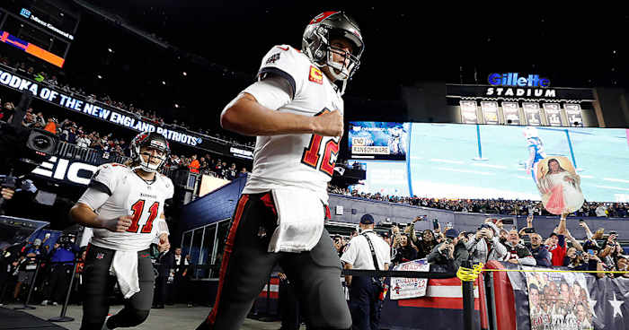Brady runs out of the tunnel in his return to Gillette Stadium with the Buccaneers in 2021.